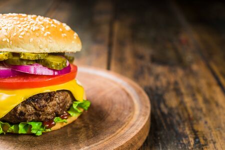Cheese burger with cheese against wooden background. Tasty fast food.の写真素材