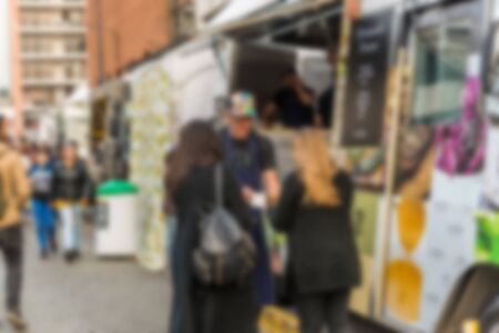 People at a street food market festival on a sunny day. Blurred on purpose.の写真素材