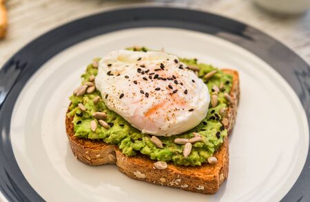 Avocado toast with poached egg. Vegetarian food and healthy eating concept.の写真素材
