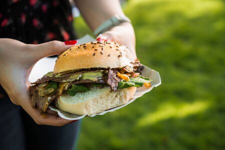 Sandwich with lamb meat, spinach, and melted cheese at a street food marketの写真素材