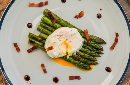 Food photography of a poached egg with asparagus, and crispy baconの写真素材