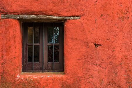 Colorful red vintage retro window and wall of an old house buildingの写真素材