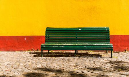 Colorful green vintage retro bench and colorful wall of an old house buildingの写真素材