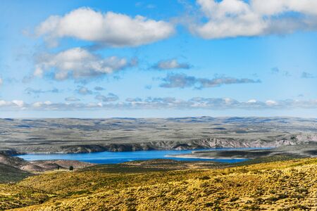 Landscape of turquoise lake and yellow steppes in Patagonia, Argentina.の写真素材