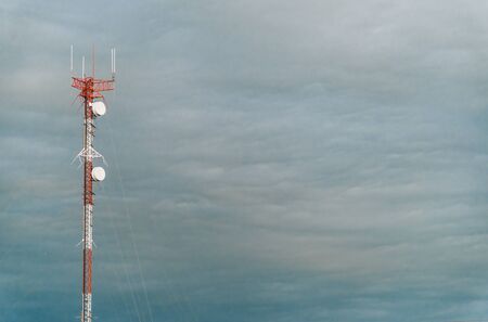 Colorful mobile phone network telecommunication tower against blue sky.の写真素材