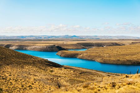 Landscape of turquoise lake and yellow steppes in Patagonia, Argentinaの写真素材