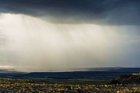 Background of rain, dark clouds, steppes, and mountains in Patagonia, Argentinaの写真素材