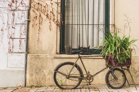 A retro vintage old bicycle against the wall of a colonial and colorful house.の写真素材