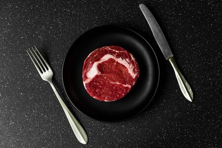 Raw prime beef rib eye meat food steak against black stone backgroundの写真素材