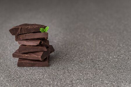 A stack of dark milk chocolate against gray stone backgroundの写真素材