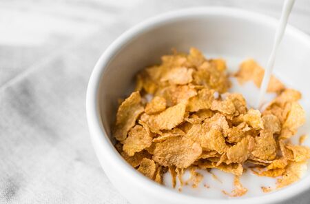 Bowl of breakfast cereals with a swig of milk pouring into itの写真素材