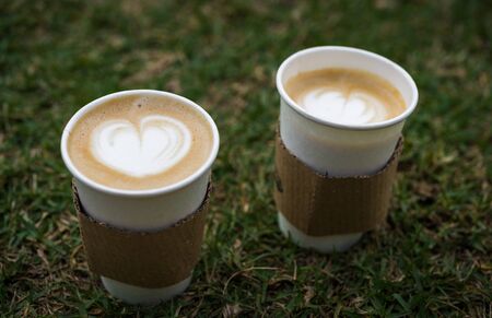 Close up of latte cappuccino coffee cup with frothed milk in heart shapeの写真素材