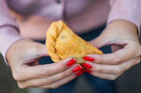 Eating traditional fried Spanish and Argentine empanadas at street food marketの写真素材
