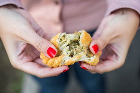 Eating traditional fried Spanish and Argentine empanadas at street food marketの写真素材