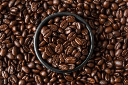 Roasted coffee beans in a black bowlの写真素材