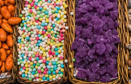 Colorful sprinkle sugar candy for cake decoration in wooden baskets.の写真素材