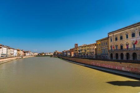 Colorful Italian houses in Pisa, Italy, alongside the embankment of Arno riverの写真素材