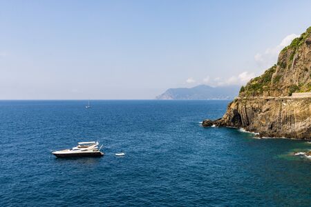 Ligurian Sea coastline in Liguria, Italy, with aquamarine water and boats.の写真素材