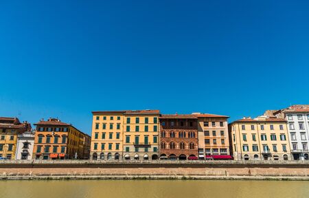 Colorful Italian houses in Pisa, Italy, alongside the embankment of Arno river.の写真素材