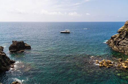 Ligurian Sea coastline in Liguria, Italy, with aquamarine water and boats.の写真素材