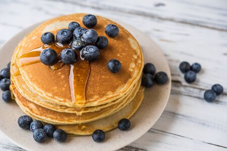 Close up of fluffy pancakes with maple syrup and blueberriesの写真素材