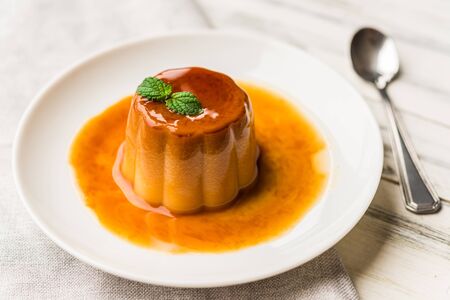 Close up of a flan creme caramel pudding with mint, a custard dessertの写真素材