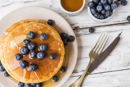 Close up of fluffy pancakes with maple syrup and blueberriesの写真素材