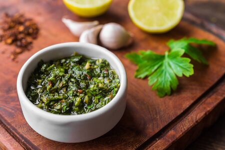 Traditional Argentinian chimichurri sauce against wooden background.の写真素材