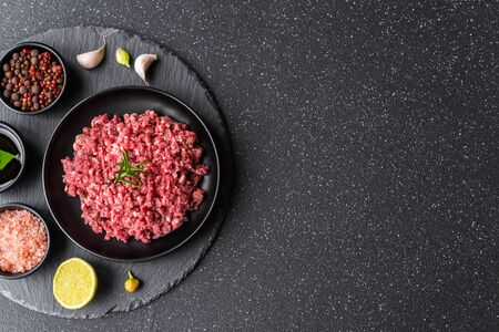 Fresh minced meat ground beef on a black plate against stone background.の写真素材