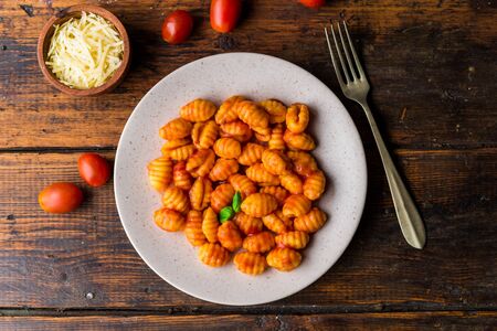 Gnocchi with tomato sauce, basil, and cheese, traditional Italian pasta food.の写真素材