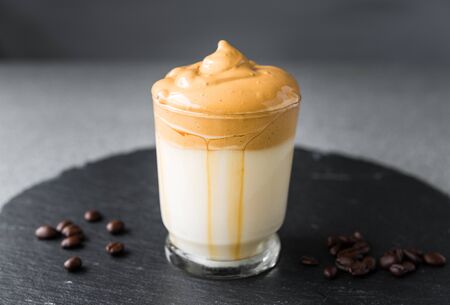 Dalgona coffee whipped cream mousse against grey background.の写真素材