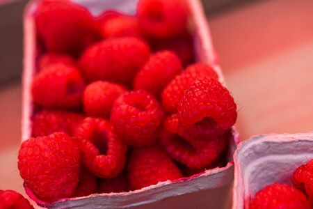 Close up food photo of organic raspberries at the farmers market stall.の写真素材