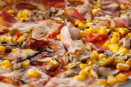 Fresh pizza close up with sausage, corn, pepper and cheeseの写真素材