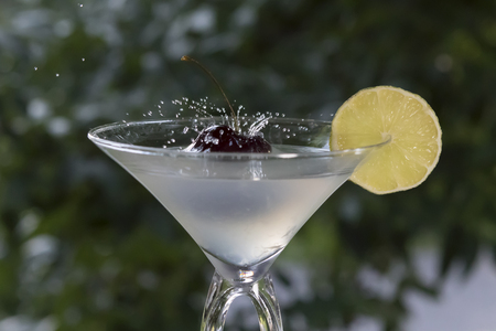 maraschino cherry dropped in a glass with a lemon sliceの写真素材