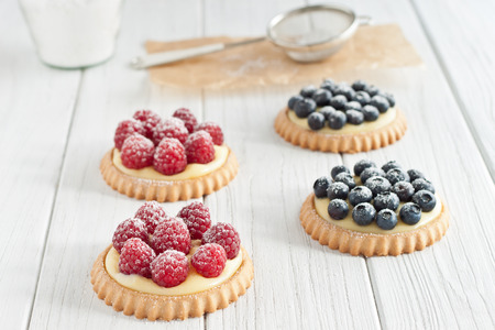 Blueberry and raspberry tartlets with icing sugarの写真素材
