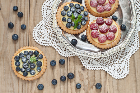 Blueberry and raspberry tartlets on a silver platterの写真素材