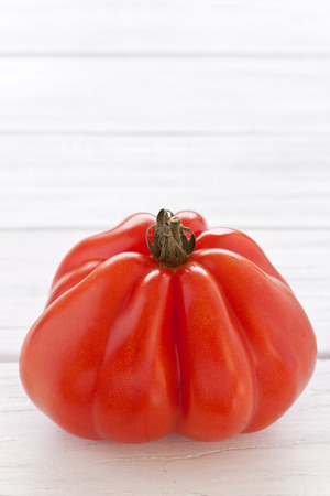 Oxheart tomato on a white wooden boardの写真素材
