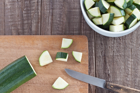 Zucchini cut in pieces on a wooden boardの写真素材