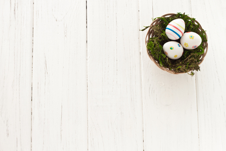 Easter eggs with a nest of grass in a basketの写真素材