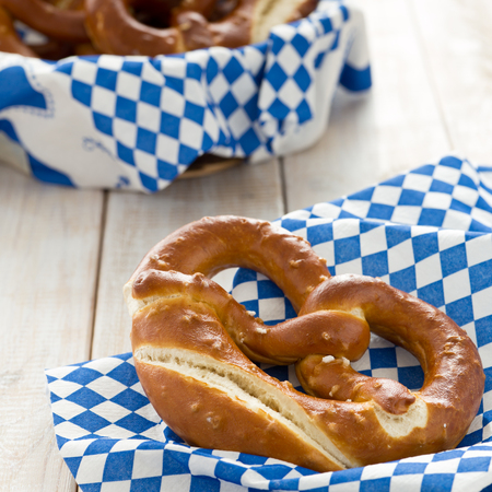 Freshly baked pretzels with bread basket and white-blue Bavarian napkinの写真素材