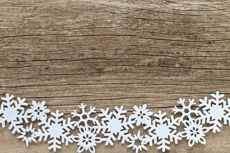 Christmas background  with white snowflakes on a wooden backgroundの写真素材