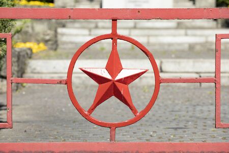 Red metal star in circle. Red army star symbol forged in metal gate to Russian military cemetery. Katowice Polandの写真素材