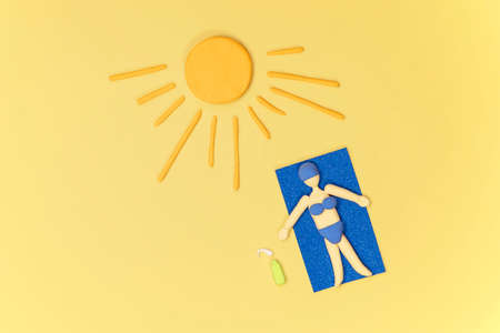 Sunburn care concept. Woman taking sunbath with uv protection cream. Women laying on the beach taking a sunbath. Top view. Summer holiday.の写真素材