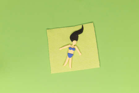 Woman laying in the grass on the blanket. Relax in the greenery, resting in the garden concept. Top view. Artificial abstract scene, leisure in the green environment during vacations.の写真素材