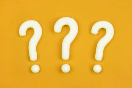 Three question marks on orange background. 3d model, mock-up of interrogation point. Asking concept. Why, FAQ. Query for important information.の写真素材