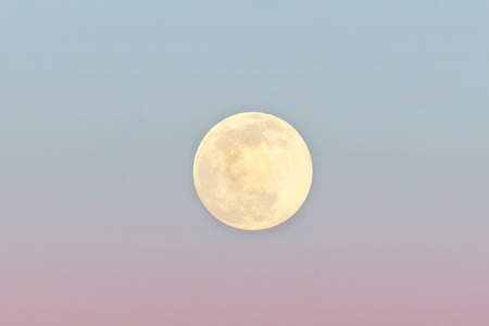 Full moon on sunset sky, close-up. Pink and blue, dreamlike moon.の写真素材