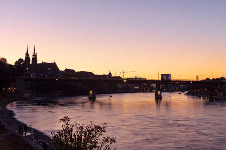 Basel, Switzerland. View on the city and bridge over Rhine river at sunset sky.