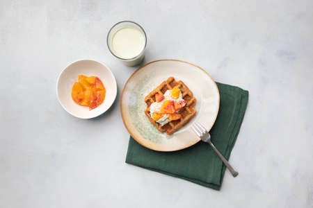 Vegan, gluten free waffles with pudding, oranges and green milk on blue neutral background. Healthy meal, tasty homemade breakfast.の写真素材