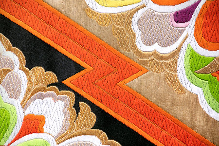 Japanese vintage textile, obi close-up with floral motif. Close-up of elegant and splendid fabric with a floral ornament, vibrant colors, japanese culture.の写真素材