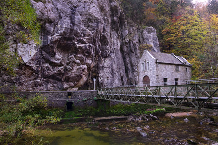 Gorges de l'Areuse, Boudry, Neuchatel, Switzerland, Europe. Beautiful romantic autumn landscape with bridge and architecture. River in the Jura Mountains. Massive rock by the riverbank.の写真素材